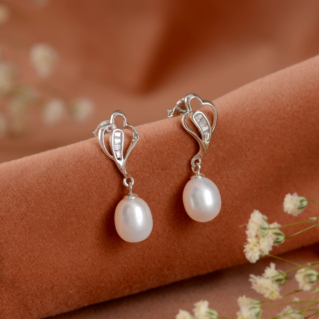 Silver paan leaf earrings with pearls.