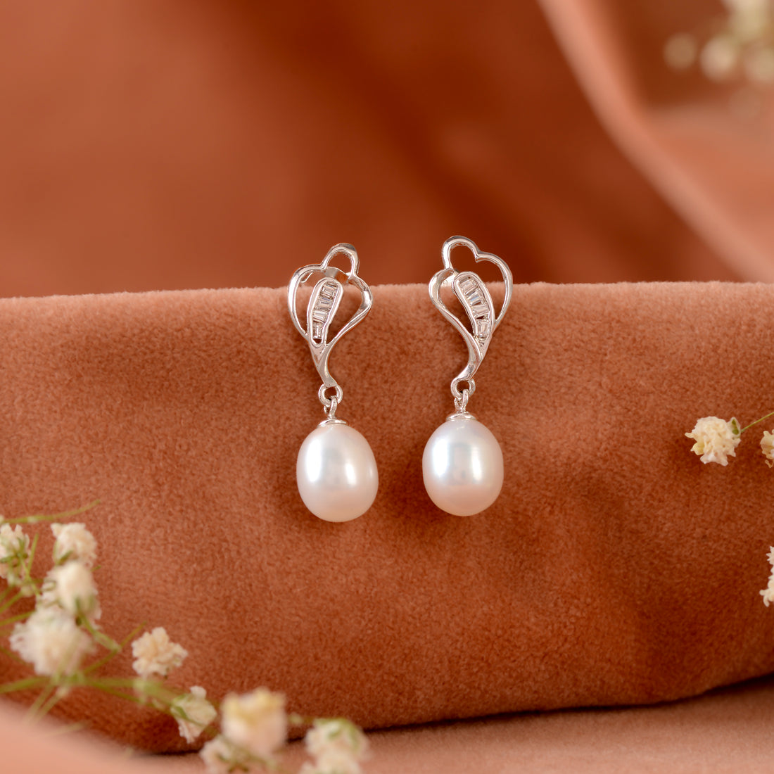 Silver paan leaf earrings with pearls.